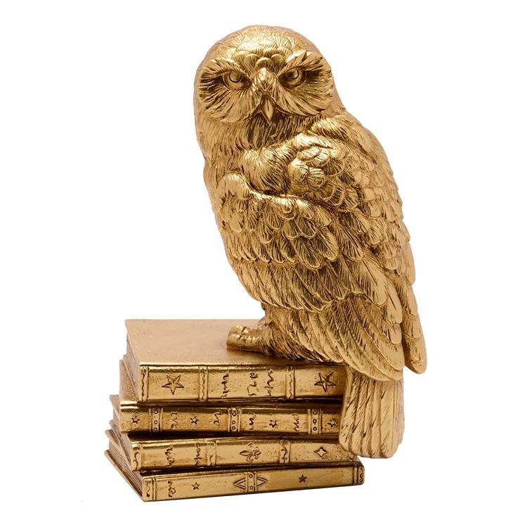 Szobor - Hedvig bagoly. Harry Potter hűséges hóbaglya, Hedvig látható rajta, amint egy stílusos, egymásra pakolt varázskönyvekből álló tornyon kuporog.